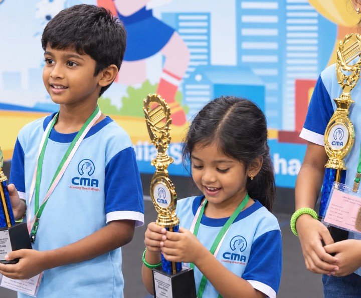 A young CMA student smiling at her trophy